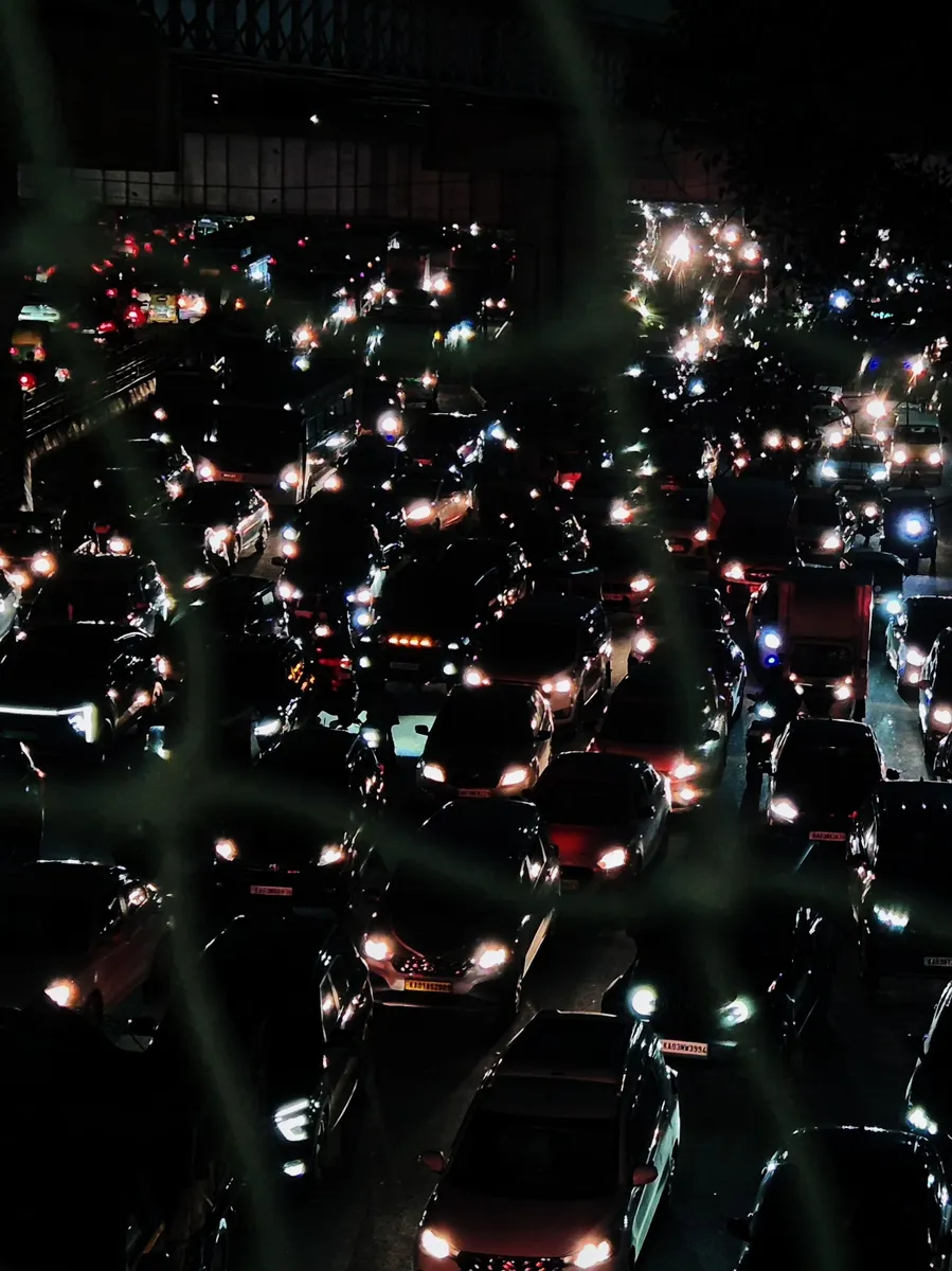 Night traffic seen from above, headlights and tail lights packed across every lane